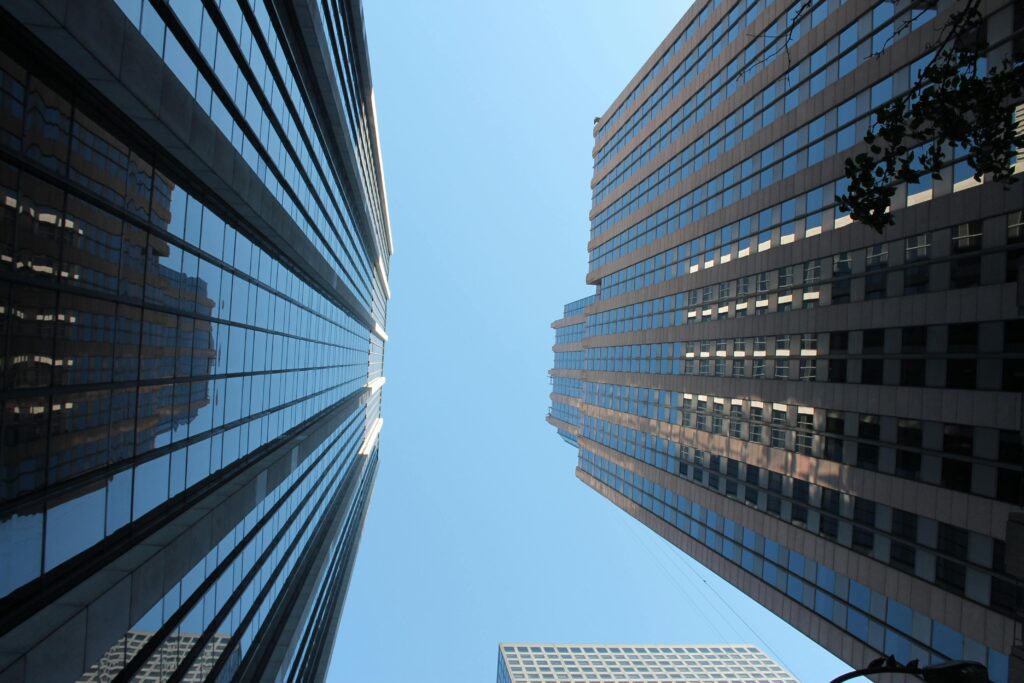 Stunning view of towering skyscrapers reaching towards the clear blue sky in a bustling cityscape.